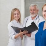 Happy patient and doctors posing, smiling